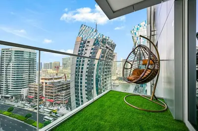 a balcony with a swing and a view of a city at Heart of Downtown - Dubai Mall & Burj next door in Dubai