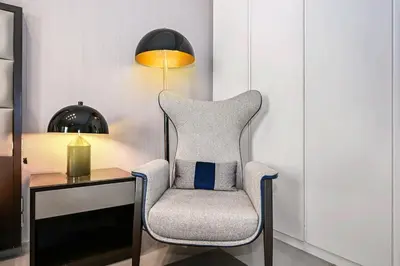 a chair sitting next to a desk with a lamp at Heart of Downtown - Dubai Mall & Burj next door in Dubai