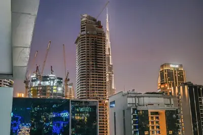 a group of skyscrapers in a city at night at Heart of Downtown - Dubai Mall & Burj next door in Dubai