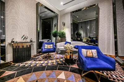 a living room with blue chairs and a couch at Live in the Center - Walk to Dubai Icons in Dubai