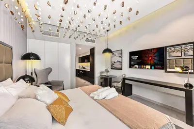 a bedroom with a large bed and a desk at Live in the Center - Walk to Dubai Icons in Dubai