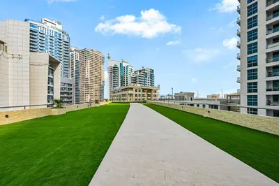 a walkway in the middle of a city with tall buildings at Chic Marina View - Timeless Studio Escape in Dubai
