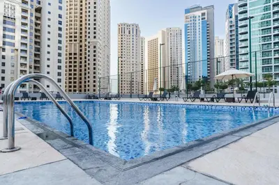 a swimming pool in a city with tall buildings at Elegant 3-Bedroom Haven - Panoramic Marina Views in Dubai
