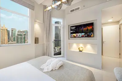 a bedroom with a bed and a tv on a wall at Elegant 3-Bedroom Haven - Panoramic Marina Views in Dubai