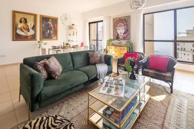 a living room with a green couch and a table at Frank Porter - Rimal 1, JBR in Dubai