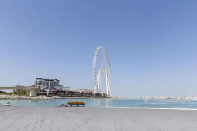 a beach with a ferris wheel in the background at Frank Porter - Rimal 1, JBR in Dubai