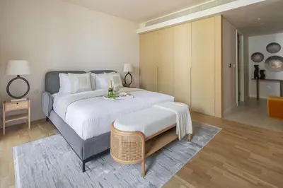 a bedroom with a large white bed with a table at Frank Porter - Bluewaters Residences 5 in Dubai
