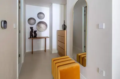a bathroom with an orange stool and a mirror at Frank Porter - Bluewaters Residences 5 in Dubai