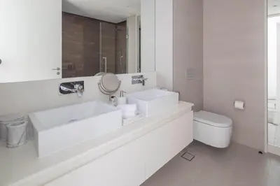 a white bathroom with a sink and a toilet at Frank Porter - Bluewaters Residences 5 in Dubai