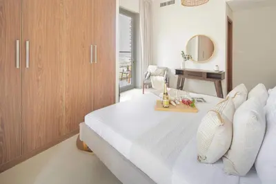 a bedroom with a white bed and a mirror at Frank Porter - Dunya Tower, Downtown in Dubai