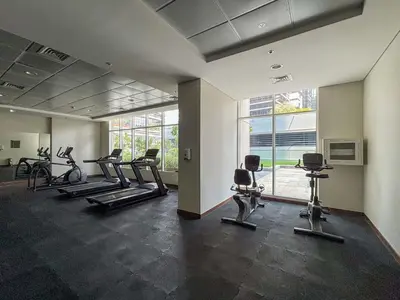 a gym with several treadmills and exercise bikes at Frank Porter - Dunya Tower, Downtown in Dubai