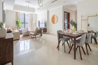 a dining room and living room with a table and chairs at Frank Porter - Dunya Tower, Downtown in Dubai