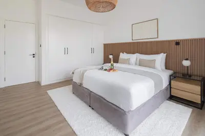 a large bedroom with a large white bed and a mirror at Frank Porter - Lago Vista Tower A in Dubai