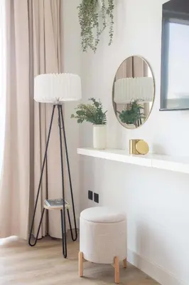 a room with a floor lamp and a chair and a mirror at Frank Porter - Lago Vista Tower A in Dubai