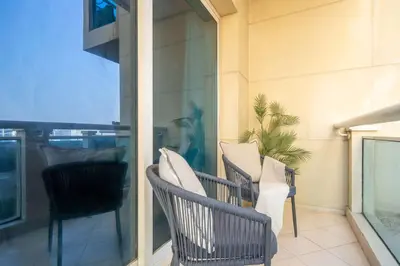 a balcony with two chairs and a window at Frank Porter - Lago Vista Tower A in Dubai