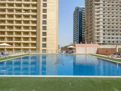 a large swimming pool in front of two tall buildings at Frank Porter - Lago Vista Tower A in Dubai
