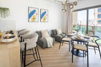 a living room with a table and chairs and a couch at Frank Porter - Lago Vista Tower A in Dubai