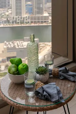 a table with a bottle of water and a bowl of fruit at Frank Porter - Dt1 Tower, Downtown Dubai in Dubai