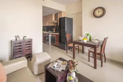 a kitchen and living room with a table and a clock at Frank Porter - Dt1 Tower, Downtown Dubai in Dubai