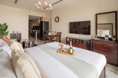 a living room with a large white bed with a table at Frank Porter - Dt1 Tower, Downtown Dubai in Dubai