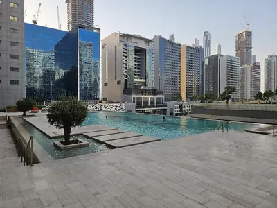 a swimming pool in a city with tall buildings at DAMAC Majestine Studio with Pool, Spa and Gym Near Bus & DubaiMall in Dubai