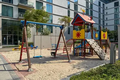 a playground in front of a building at Modern and Elegant 1 Bed Retreat in Prime Location in Dubai