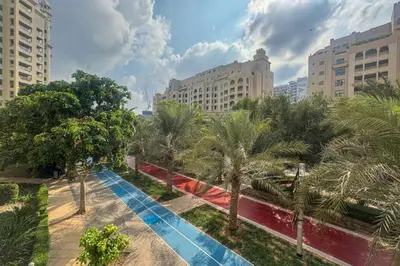 a city street with palm trees and buildings at Elegant Palm Living Upgraded Golden Mile 1 Bed in Dubai