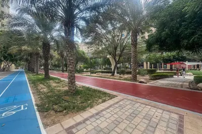 a park with palm trees and a basketball court at Elegant Palm Living Upgraded Golden Mile 1 Bed in Dubai