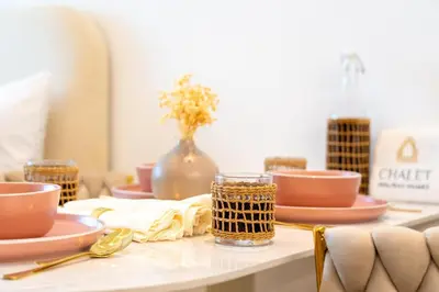 a table with plates and bowls and a vase with flowers at Nice New Studio 2 Double Beds In Downtown, Free Parking in Dubai