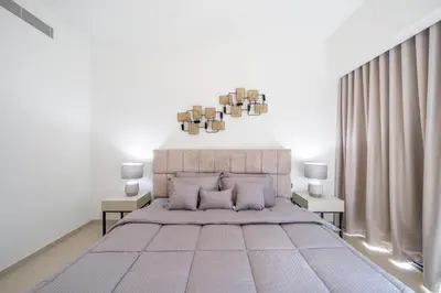 a bedroom with a large bed with white walls at Act tower 2BR, near burj khalifa in Dubai