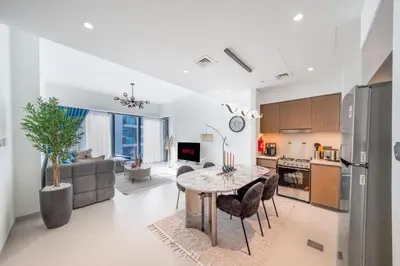 a kitchen and living room with a table and chairs at Act tower 2BR, near burj khalifa in Dubai