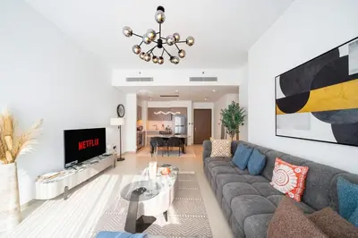 a living room with a couch and a tv at Act tower 2BR, near burj khalifa in Dubai