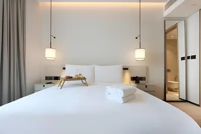 a bedroom with a large white bed and two lights at Scenic 1BR - The Address JBR in Dubai