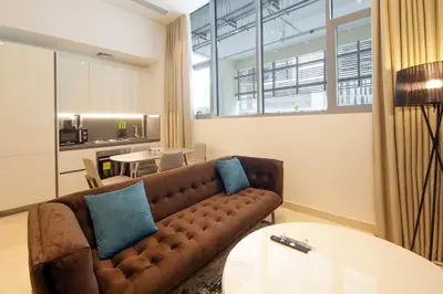 a living room with a couch and a table at The Sterling By OMNIYAT Near To Dubai Mall in Dubai