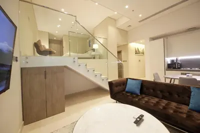 a living room with a couch and a table at The Sterling By OMNIYAT Near To Dubai Mall in Dubai