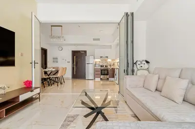 a living room with a white couch and a table at FIRST CLASS 1BR Luxe Living in Jewelz in Dubai