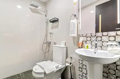 a white bathroom with a toilet and a sink at FIRST CLASS 1BR Luxe Living in Jewelz in Dubai