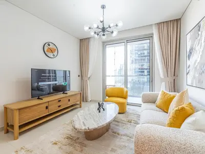 a living room with a couch and a tv at 1BR at Vida -Steps from Dubai Mall & Burj Khalifa in Dubai