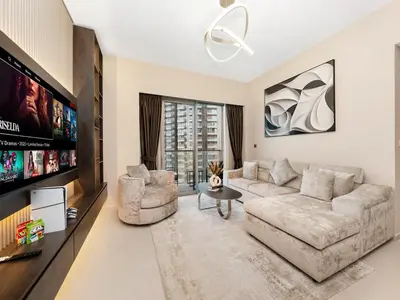 a living room with a couch and a tv at Skyline View - 2 Balconies - Pool plus Gym - Sleeps 8 in Dubai