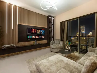a living room with a couch and a tv at Skyline View - 2 Balconies - Pool plus Gym - Sleeps 8 in Dubai