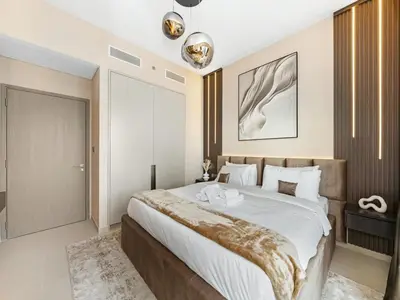 a bedroom with a large bed with white sheets at Skyline View - 2 Balconies - Pool plus Gym - Sleeps 8 in Dubai