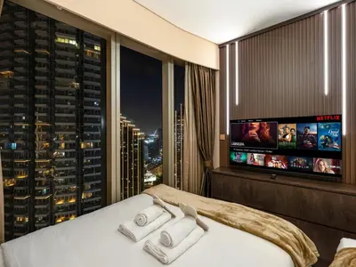 a hotel room with a bed and a large window at Skyline View - 2 Balconies - Pool plus Gym - Sleeps 8 in Dubai