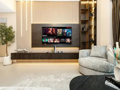 a living room with a tv on a wall at Skyline View - 2 Balconies - Pool plus Gym - Sleeps 8 in Dubai