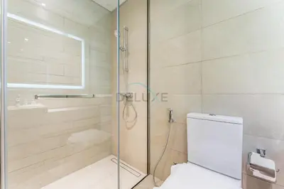 a bathroom with a shower and a toilet and a sink at Modern Studio with Huge Balcony, Near Dubai Canal and Mins to Downtown Dubai, Fawad Azizi Residence, Al Jaddaf by Deluxe Holiday Homes in Dubai