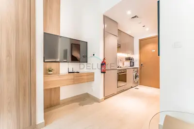 a kitchen with a flat screen tv on a wall at Modern Studio with Huge Balcony, Near Dubai Canal and Mins to Downtown Dubai, Fawad Azizi Residence, Al Jaddaf by Deluxe Holiday Homes in Dubai