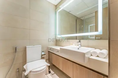 a bathroom with a sink and a toilet and a mirror at Modern Studio with Huge Balcony, Near Dubai Canal and Mins to Downtown Dubai, Fawad Azizi Residence, Al Jaddaf by Deluxe Holiday Homes in Dubai