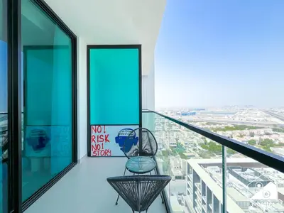 a chair on a balcony with a view of a city at JVC Retreat with Pool & Balcony in Dubai