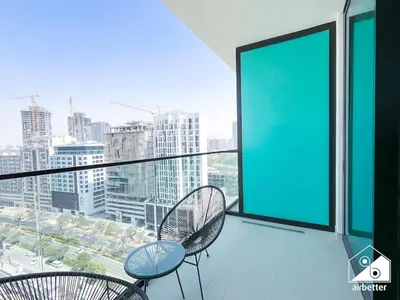 a balcony with two chairs and a large window at JVC Retreat with Pool & Balcony in Dubai