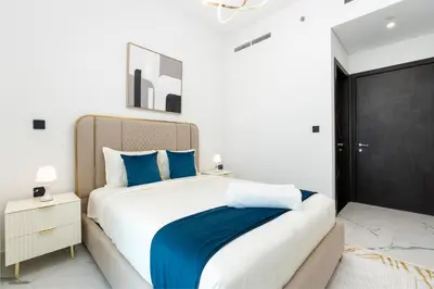 a bedroom with a large bed with blue pillows at Ahlan HH - Exclusive 2-BR Apartment in Opalz by Danube - Balcony with Mini Pool in Dubai