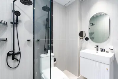 a bathroom with a shower and a toilet and a sink at Ahlan HH - Exclusive 2-BR Apartment in Opalz by Danube - Balcony with Mini Pool in Dubai